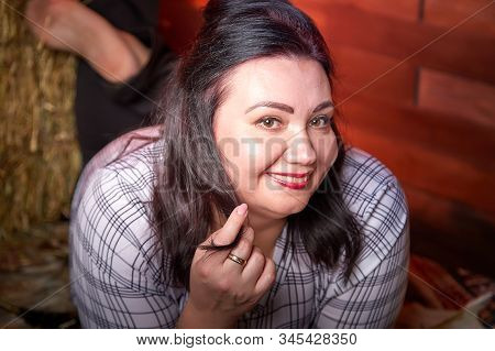 Portrait Of Fat Plump Fun Charming Cute Woman With Black Hair In The Room With Hay And Straw