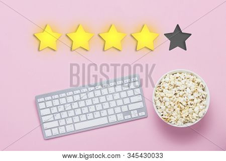 Bowl Of Popcorn, Keyboard On A Pink Background. Added Four Stars Rating. Reputation. Concept Of Watc