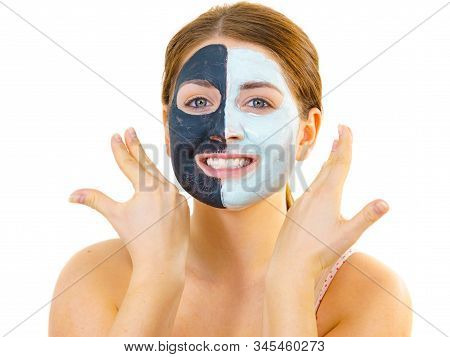 Woman With Clay Carbo Black Mask On Half Face And White Mud On Second Half. Girl Taking Care Of Oily