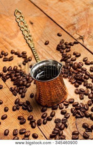 Turkish Coffee Maker And Coffee Grains On A Rustic Wooden Table