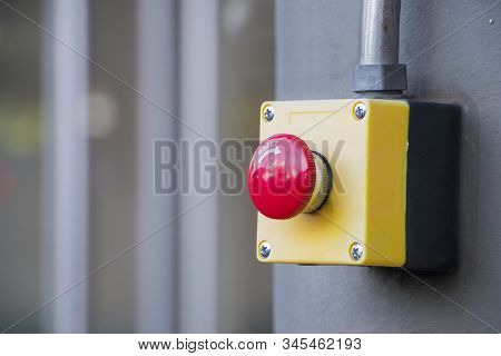 Red Reset Button On The Wall. Red Emergency Stop Switch Button In A Factory Building.