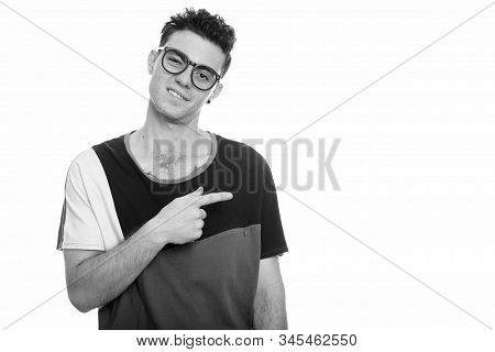 Studio Shot Of Young Man Looking Digusted While Pointing Finger