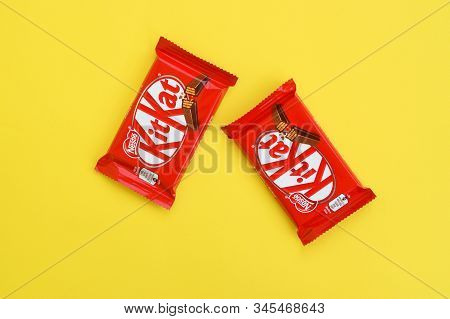 Kit Kat Chocolate Bar In Red Wrapping Lies On Yellow Background. Kit Kat Created By Rowntrees Of Yor
