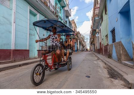 Havana, Cuba - May 13, 2019: Bicycle Taxi Driver Riding In The Streets Of Old Havana City During A V