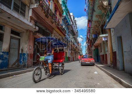 Havana, Cuba - May 13, 2019: Bicycle Taxi Driver Riding In The Streets Of Old Havana City During A V
