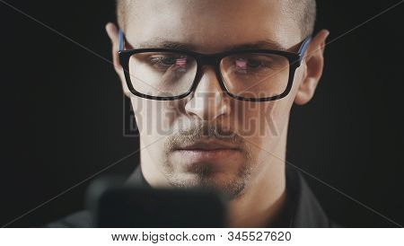 Close-up Of Attractive Serious Young Man Using Smartphone, Reflection Of His Hand And Phone Screen I