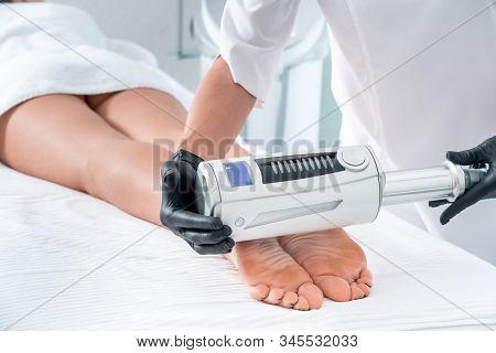 Cosmetologist In Rubber Gloves Doing Endospheres Therapy On Female Feet