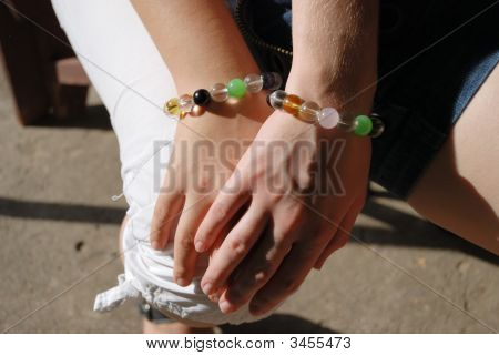 Hånd dækket med en anden hånd i lige armbånd