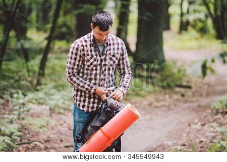 Hiker Holding His Camping Backpack. Traveler Opening Backpack While Traveling In Beautiful Wood. The