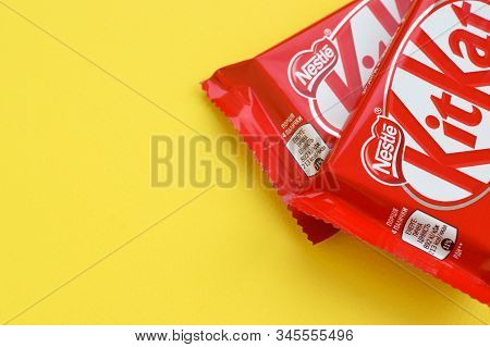 Kit Kat Chocolate Bar In Red Wrapping Lies On Yellow Background. Kit Kat Created By Rowntrees Of Yor