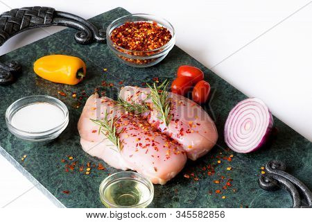 Raw Chicken Breast With Rosemary, Vegetables  And Red Pepper On Green Marble Cutting Board. Chickenb