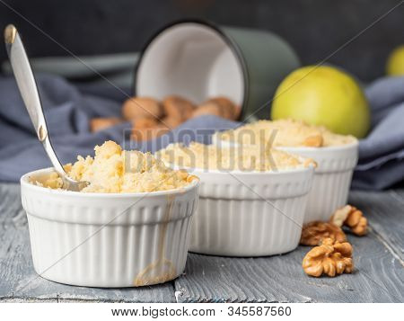Walnuts Spill Out Of A Mug Onto A Cloth, Cinnamon Sticks And Apples In A Still Life.
