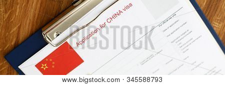 Red Passport Lie Against China Application Form Backgroung Cloceup.
