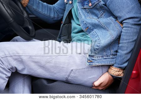Man Suffering From Hemorrhoid Pain In Car, Closeup