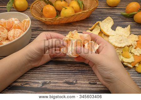 The Girls Hands Are Cleaning Tangerine, Tangerines On A Twig With Green Leaves, Peeled Tangerines In