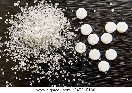 Sweetener Tablets Lying With Sugar On A Dark Background