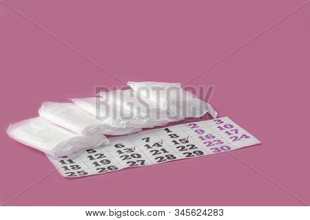 Protective Menstrual Pads And Calendar Of Menstruation Cycle (period) On Pink Background. The Concep