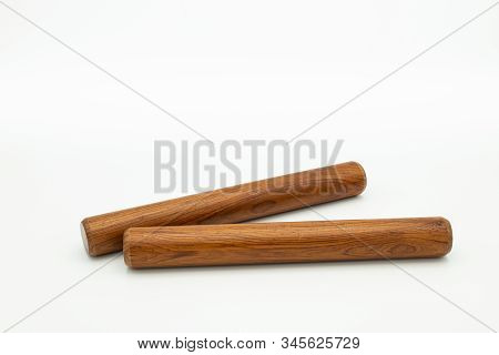 Closeup Of A Pair Of Wooden Claves Lying On A White Underground