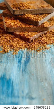 Brown Unrefined Cane Sugar On A Blue Wooden Table Close Up