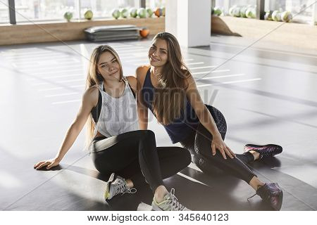 Cheerful Attractive Caucasian Women, Two Sportswoman In Sportswear, Sitting Gym Floor, Fitness Club,
