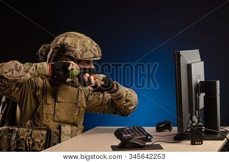 Military In Uniform Sitting At A Computer Are Cyberwar, Playing, Throwing A Grenade