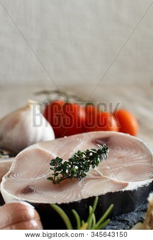 Shark Steak On A Wooden Board With Vegetables And Herbs