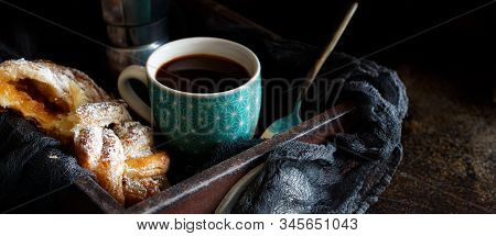 Cup Of Coffee With Croissant On A Dark Background Close Up
