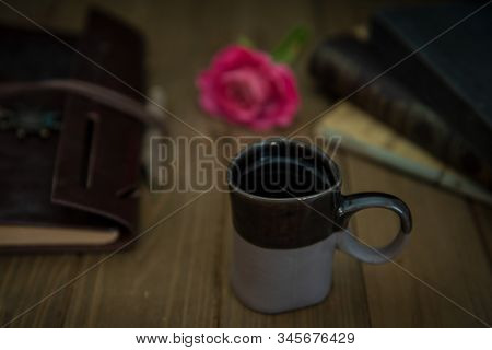 Journal, Pencil, Coffee And Hardbound Books Stacked On Wooden Desk, Against White Wall - Unplugged O