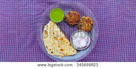 Hydrabadi Kawab Paratha With Green Chili Sauce & Onion On Transparent Plate. Kabab An Irani Dish Wit