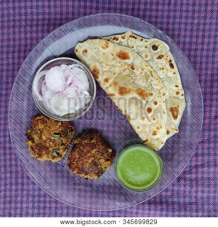 Hydrabadi Kawab Paratha With Green Chili Sauce & Onion On Transparent Plate. Kabab An Irani Dish Wit