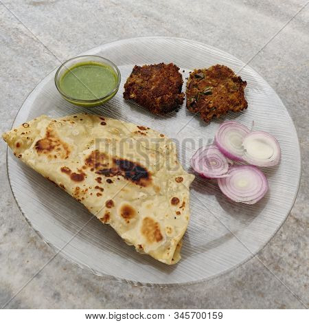 Hydrabadi Kawab Paratha With Green Chili Sauce & Onion On Transparent Plate. Kabab An Irani Dish Wit