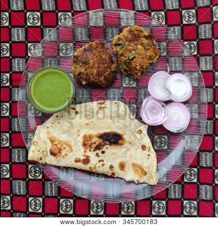 Hydrabadi Kawab Paratha With Green Chili Sauce & Onion On Transparent Plate. Kabab An Irani Dish Wit