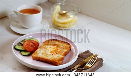 Brunch - An Egg With Sesame Seeds On Toast, Fresh Cucumber And Tomato. A Cup Of Tea With Lemon. In T