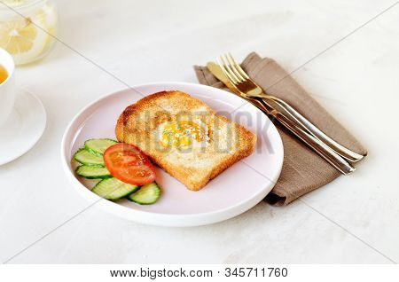 Brunch - An Egg With Sesame Seeds On Toast, Fresh Cucumber And Tomato. A Cup Of Tea With Lemon. In T