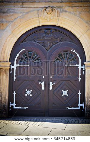 Wooden doors with round parts at top. Reliefs of angels above the doors. Entrance in ancient building in Celle, Germany. 