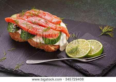 Salted Salmon Sandwich With Cream Cheese And Cuccumber On Slate Platter Closeup