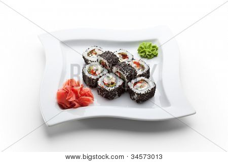Cozinha japonesa - rolo de Sushi com camarão, enguia, folhas de salada, queijo de creme e Tobiko dentro. Gergelim 