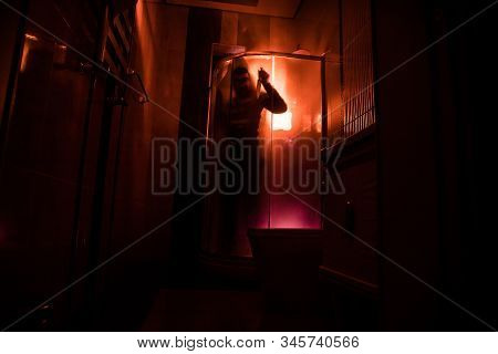 Horror Silhouette Of Person In Window. Scary Halloween Concept Blurred Silhouette Of Witch In Bathro