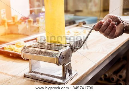 Chef Rolling Dough With A Pasta Machine. Pasta Maker Machine. Homemade Italian Style Cuisine. Restau
