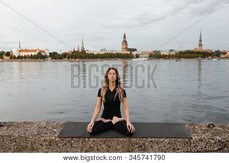 Yoga Meditation And Wellness Lifestyle Concept. Fit Slim Woman Practicing Yoga Exercises Near River 