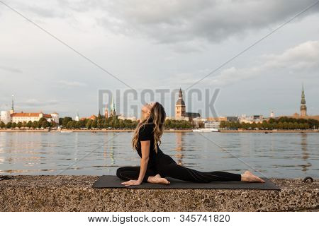 Yoga Meditation And Wellness Lifestyle Concept. Fit Slim Woman Practicing Yoga Exercises Near River 