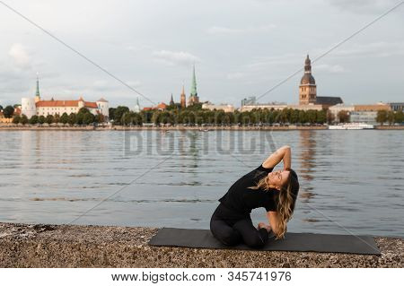 Yoga Meditation And Wellness Lifestyle Concept. Fit Slim Woman Practicing Yoga Exercises Near River 