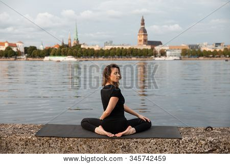 Yoga Meditation And Wellness Lifestyle Concept. Fit Slim Woman Practicing Yoga Exercises Near River 