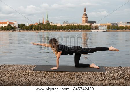 Yoga Meditation And Wellness Lifestyle Concept. Fit Slim Woman Practicing Yoga Exercises Near River 
