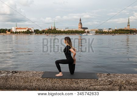 Yoga Meditation And Wellness Lifestyle Concept. Fit Slim Woman Practicing Yoga Exercises Near River 