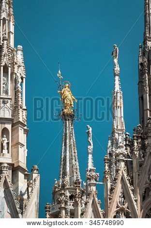 Milan Cathedral Spires, Italy. Golden Statue Of Madonna On Blue Sky Background. Famous Milan Cathedr