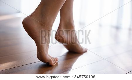 Close Up Side View Beautiful Female Feet On Wooden Floor
