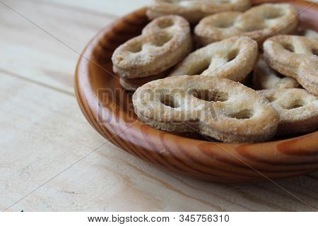 Close Up, Side On View Of A Wooden Bowl Filled With Krakeling A Very Popular Sort Of Dutch Cookie. W