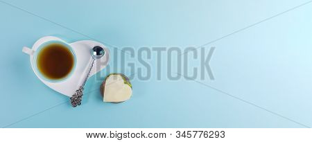 Cup Of Tea And Silver Spoon On White Saucer In Heart Shape And Sandwich In Heart Shape On Light Blue