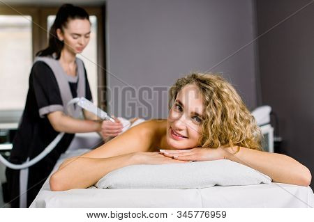 Beautiful Blond Woman Smiling, Looking At Camera While Getting Ultrasound Cavitation Treatment By Co